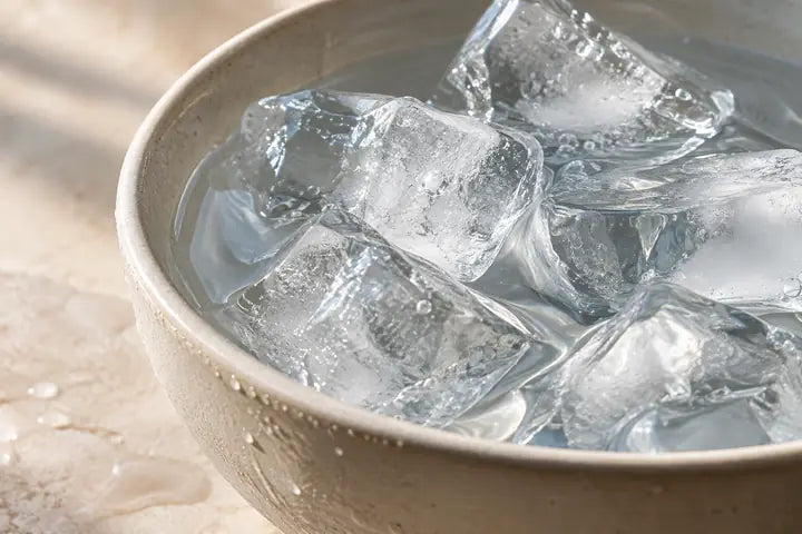 Ice and clear water in an ivory bowl.